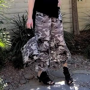 Close up of woman modeling LYC Gaucho Pants in Desert Black Ops with matching handbag.